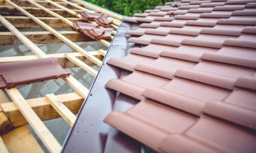 Roof building at new house construction. Brown roof tiles covering estate